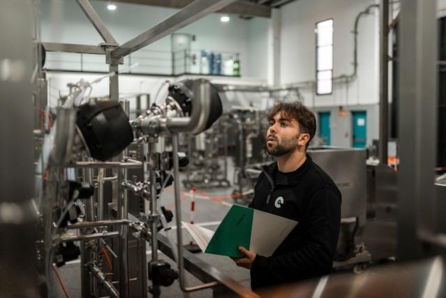 An engineer checking plant equipment against a paper checklist